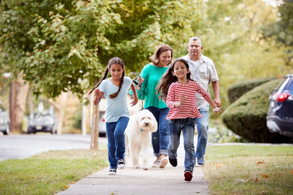 family walking on the street with their dog